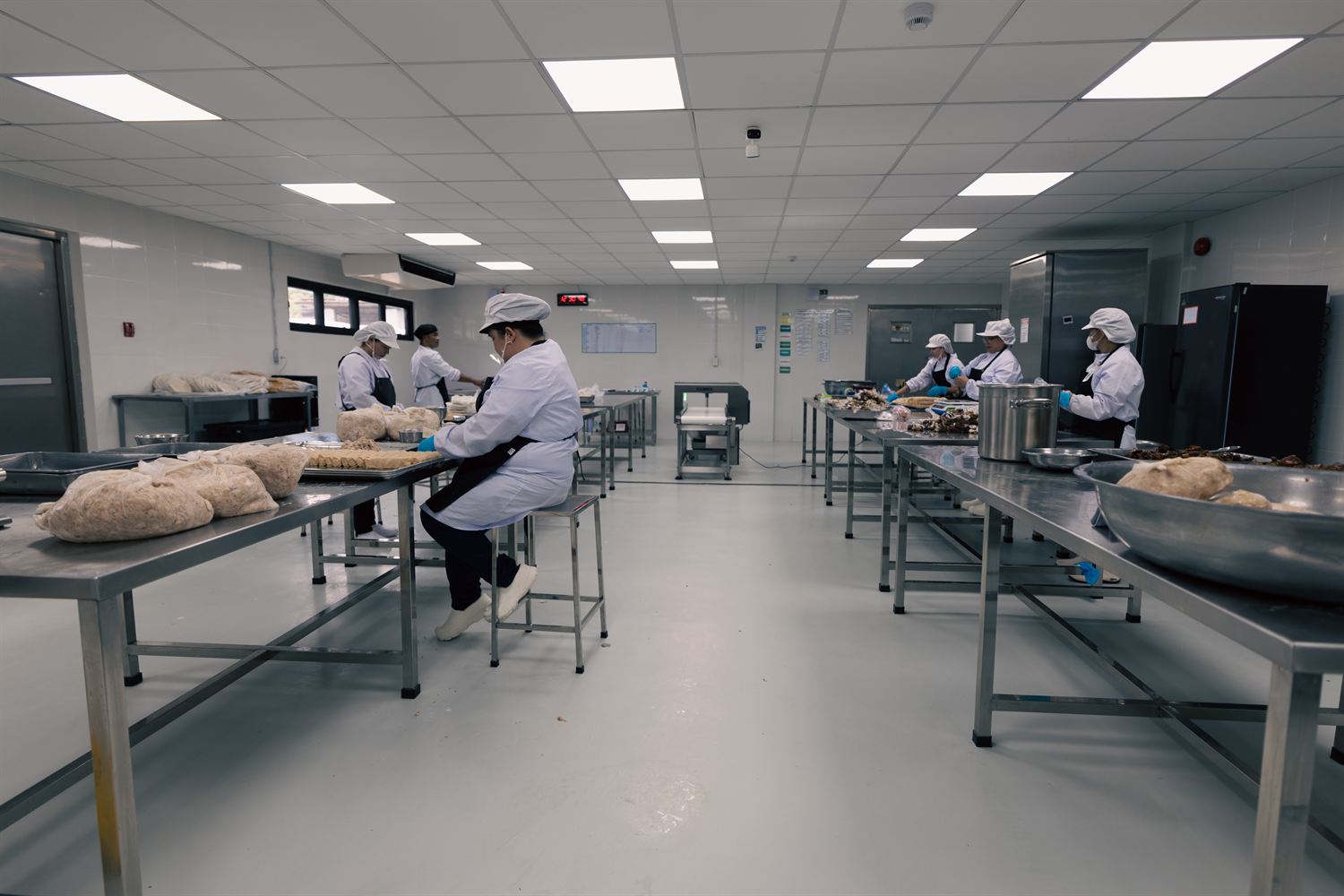 Kwatogs commissary production team preparing ingredients at stainless-steel work tables