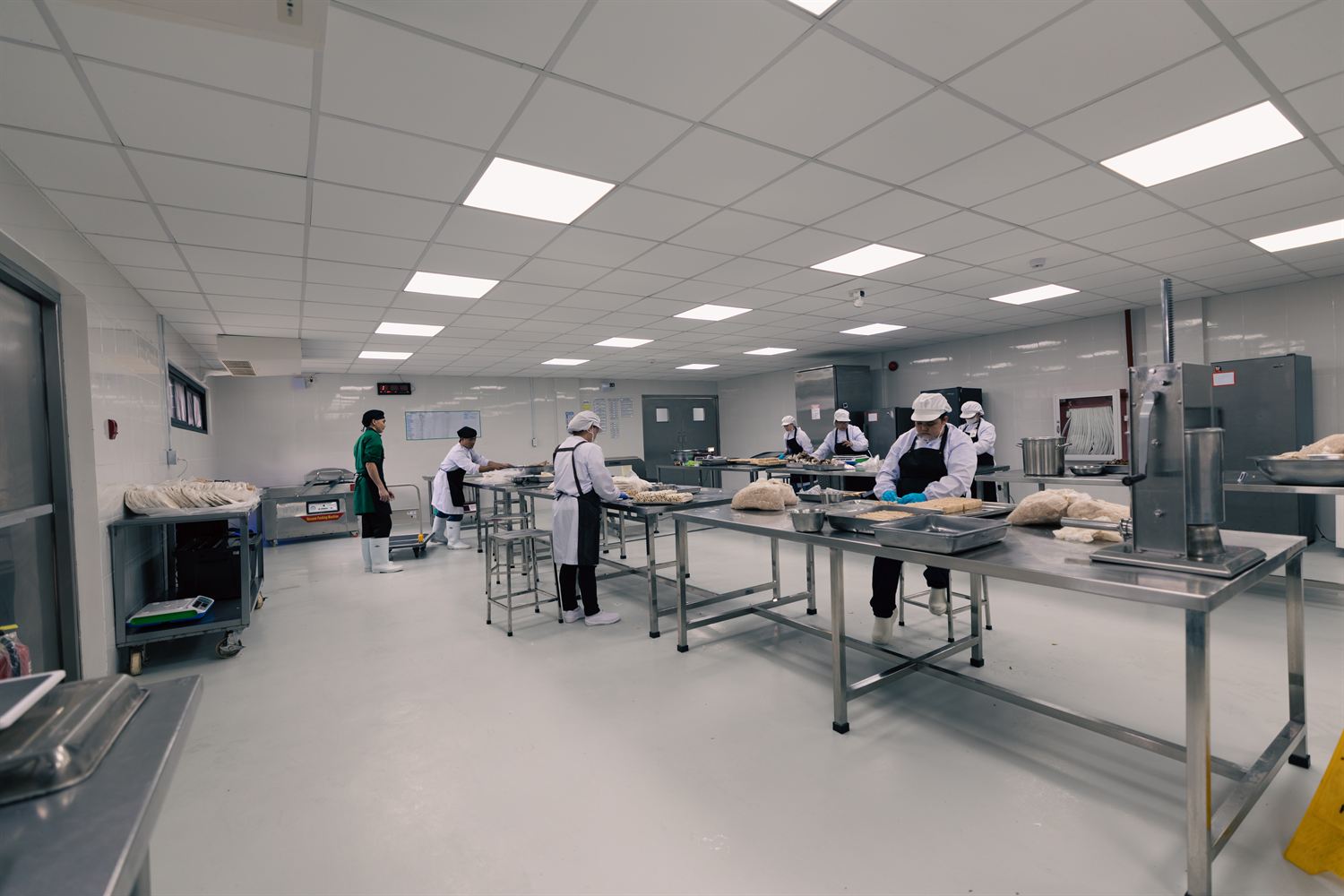 Wide view of the Kwatogs commissary with staff working across multiple prep stations