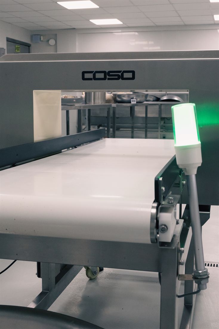 Stainless-steel conveyor food-safety screening equipment on the commissary line